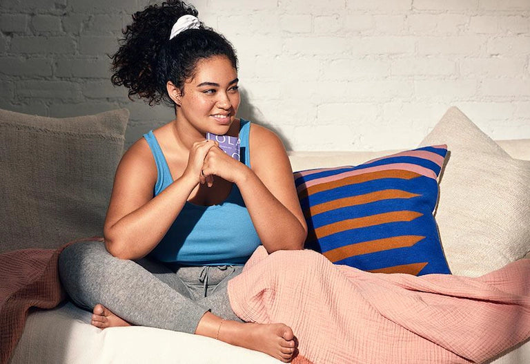 Ultra thin liners| Women sitting on couch holding a liner