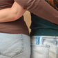 Two people wearing jeans with a visible brand label.
